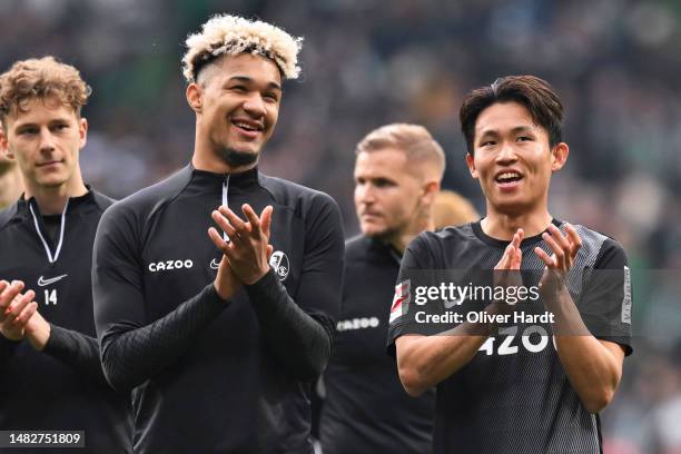 Tan Kenneth Jerico Schmidt and Wooyeong Jeong of Sport Club Freiburg applauds the fans after the Bundesliga match between SV Werder Bremen and...