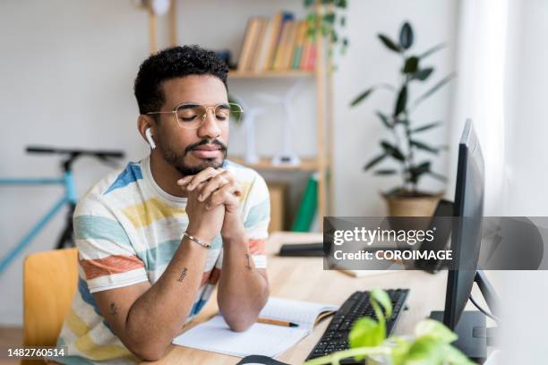 young entrepreneur thinking with eyes closed at the desk. - headphones eyes closed stock pictures, royalty-free photos & images