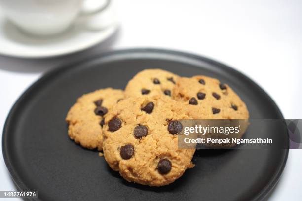 chocolate chip cookies on black plate - chocolate chip cookies stock pictures, royalty-free photos & images