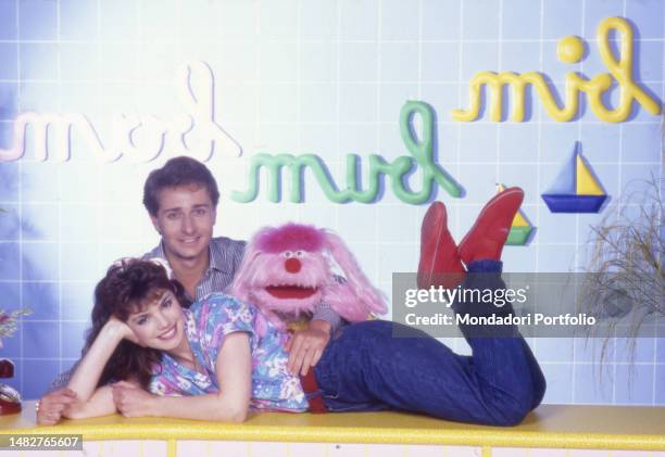 Italian television hosts Paolo Bonolis and Manuela Blanchard in the television studio of Bim Bum Bam with puppet Uan. Italy, 1987