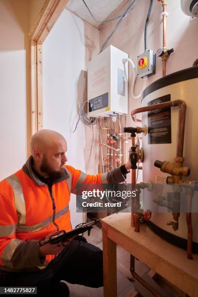 heating engineer installing system - heating engineer stock pictures, royalty-free photos & images