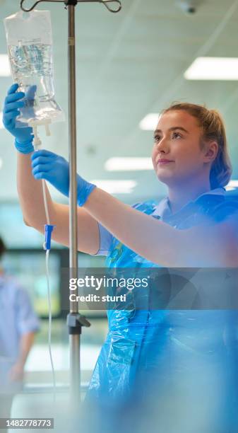 student nurse adjusting iv - medical student stock pictures, royalty-free photos & images