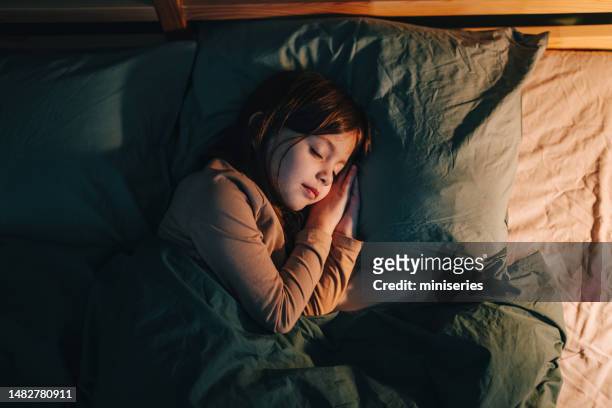 hochwinkelansicht eines kleinen mädchens, das nachts in ihrem bett schläft - kids sleep in bed stock-fotos und bilder