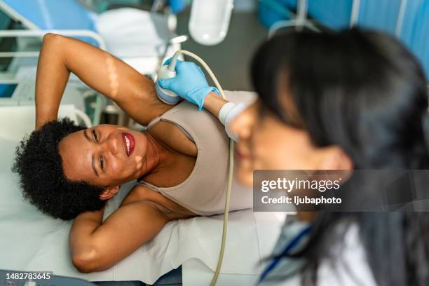 doctor doing ultrasound examination of breast of patient in clinic - mammogram diversity stock pictures, royalty-free photos & images