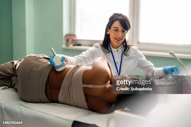 lo specialista medico conduce un esame dei reni del paziente - obstetrician foto e immagini stock