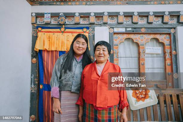 retrato de abuela y nieta butanesas mirando a la cámara sonriendo - bután fotografías e imágenes de stock