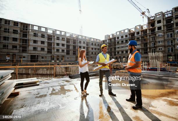 mid adult and mature diverse engineers having meeting on construction site - a meeting place for the european digital industry stock pictures, royalty-free photos & images