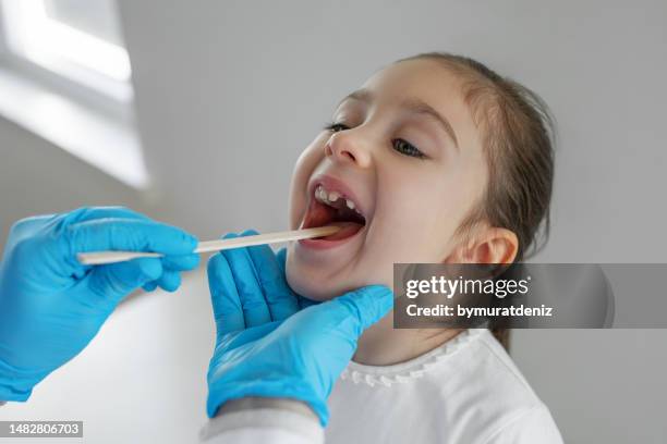 überprüfung des kleinen mädchens hals arzt - tonsille stock-fotos und bilder