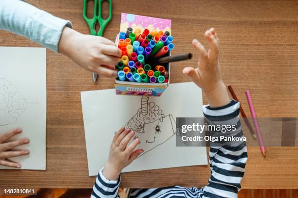 children's drawing and hands with a felt-tip pen close-up top view - table top view stock-fotos und bilder