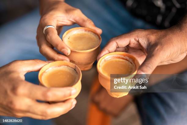 clay tea cup being hold in the hand - chai imagens e fotografias de stock