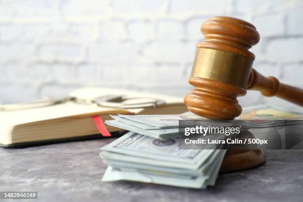 close up of gavel and cash on wooden background - geldstrafe stock-fotos und bilder