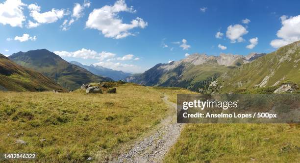 scenic view of road amidst field against sky,engadin,switzerland - engadin valley stockfoto's en -beelden