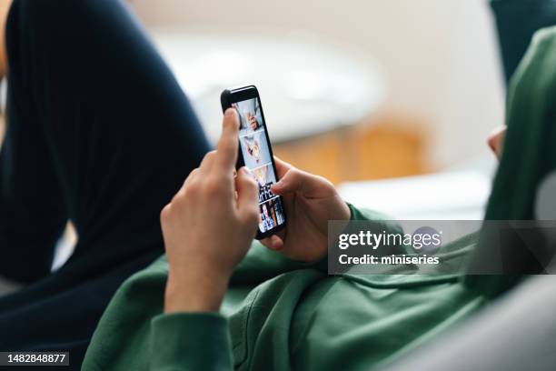 anonymous man lying on the sofa and using his mobile phone (copy space) - conformity teens stock pictures, royalty-free photos & images
