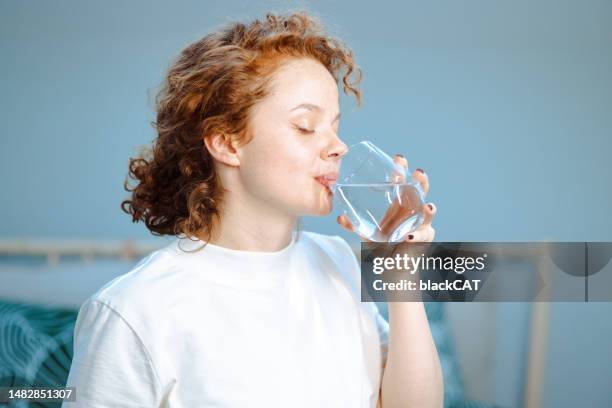 young woman drinking glass of water - cat drinking water stock pictures, royalty-free photos & images