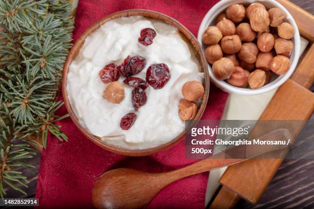 wooden and ceramic bowls with yogurt and nuts on red napkin on wooden table,romania - wooden spoon stock pictures, royalty-free photos & images