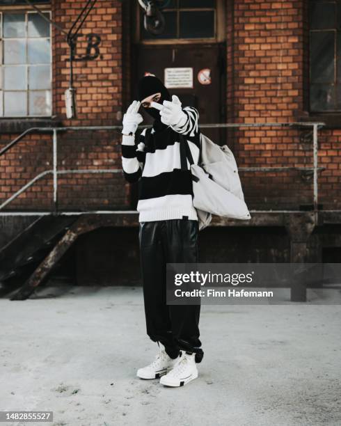 angry young man showing the finger fuck off hand sign wearing modern fashion outfit portrait - bestimmtheit stock pictures, royalty-free photos & images