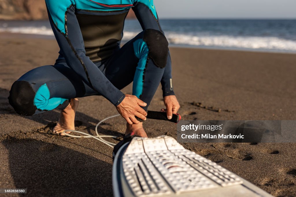 Smiling young man with surfboard on the beach.