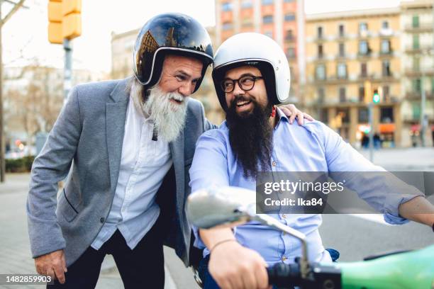 zwei bärtige business-casual-männer interagieren auf der straße - motorroller stock-fotos und bilder