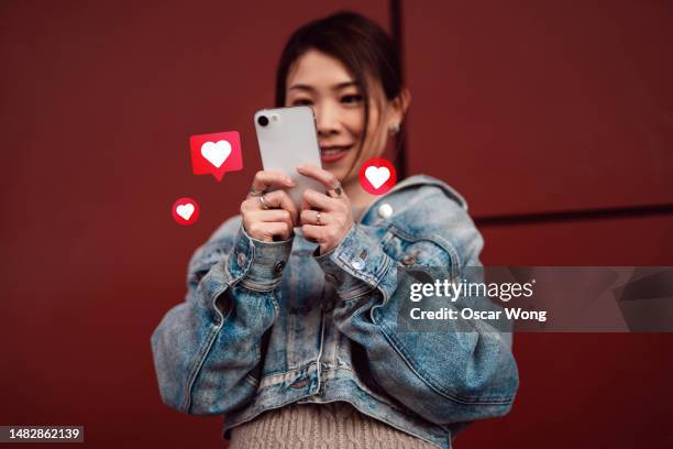 young asian woman on social media with smartphone - facebook like stock pictures, royalty-free photos & images