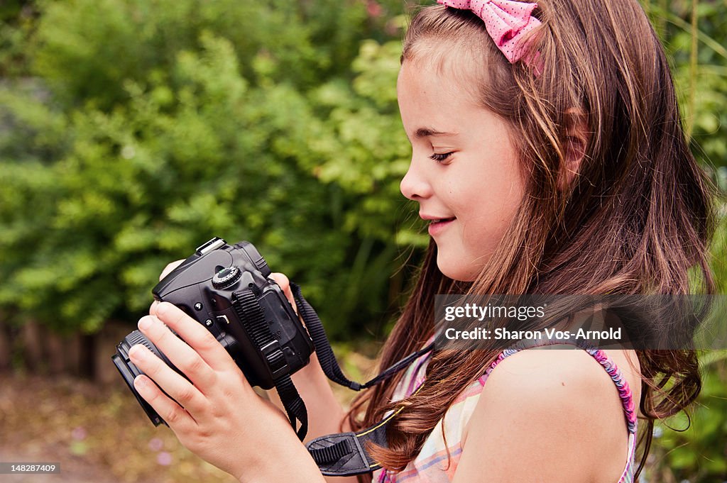 Photographer girl checking image on camera screen