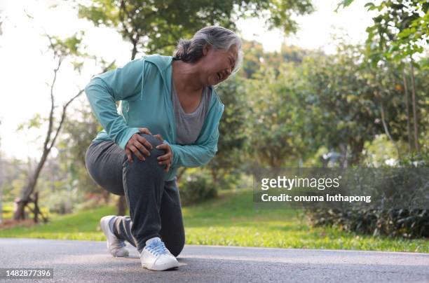 dolor de rodilla por accidente de ancianos mientras hace ejercicio en el parque - older woman legs fotografías e imágenes de stock
