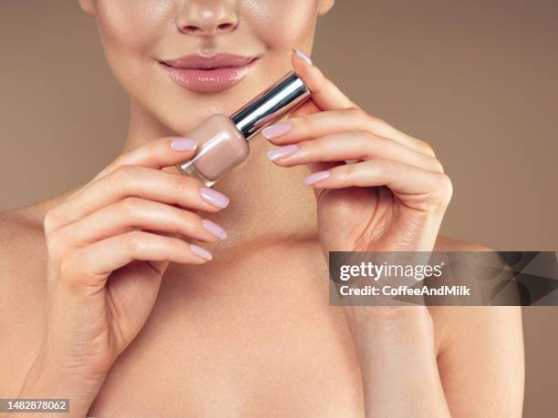 beautiful young woman painting fingernails - nail varnish stock pictures, royalty-free photos & images