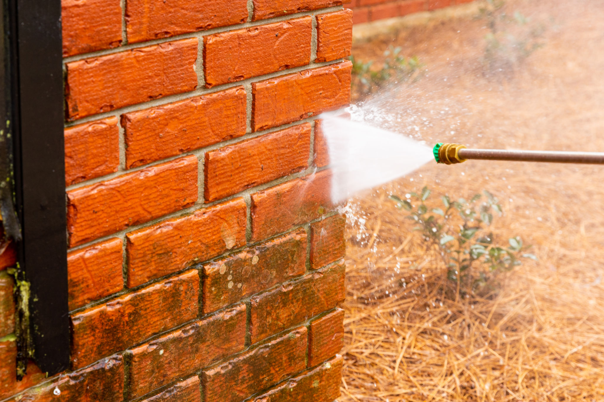 Dirty brick wall being cleaned with a pressure washer. Dirty brick wall being cleaned with a pressure washer.
