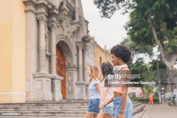 three women walking next to a church - college visit stock pictures, royalty-free photos & images