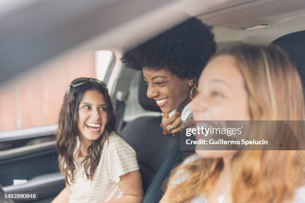 three multiethnic friends laughing inside a car - friends inside car stock-fotos und bilder