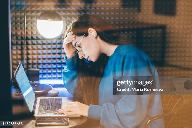 tired business woman working at a co-working space in an isolated booth. - zoom fatigue stock pictures, royalty-free photos & images