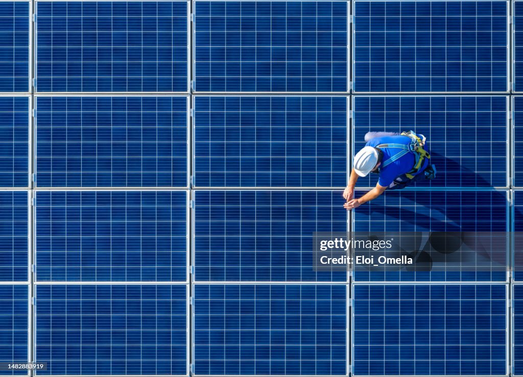 Solar panel installer installing solar panels with a big copy space