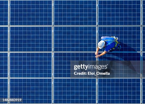 Solar panel installer installing solar panels with a big copy space Solar panel installer installing solar panels with a big copy space