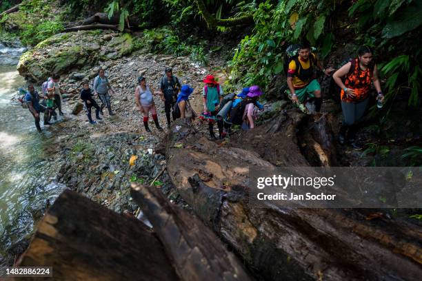 Ecuadorian migrants climb a rocky trail in the wild and dangerous jungle on November 20, 2022 in Darién Gap, Colombia. Tens of thousands of migrants...