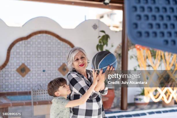 grandma and grandson play basketball in the garden of the house - old basketball hoop stock pictures, royalty-free photos & images