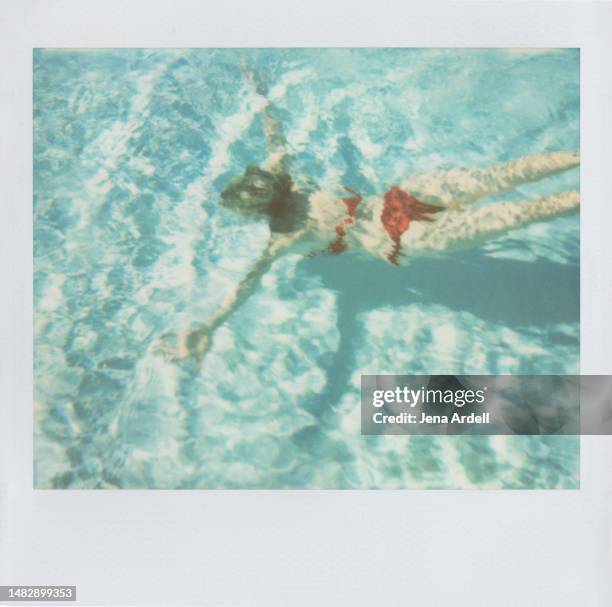 summer woman swimming pool, swimming woman underwater full length, carefree woman on vacation wearing red bikini - women swimming pool retro stock-fotos und bilder