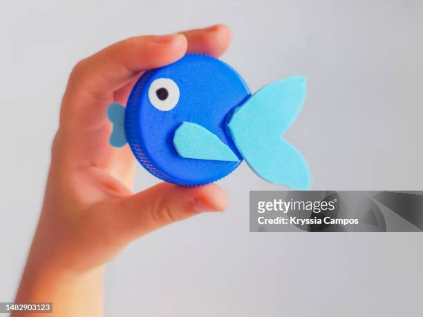 top view of child's hands holding an animal figure made with reused materials - google eyes stock pictures, royalty-free photos & images