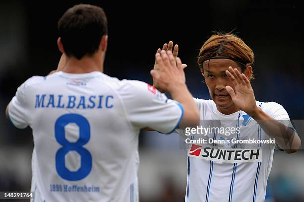 Takashi Usami of Hoffenheim celebrates with teammate Filip Malbasic after scoring his team's third goal during the friendly match between FC-Astoria...