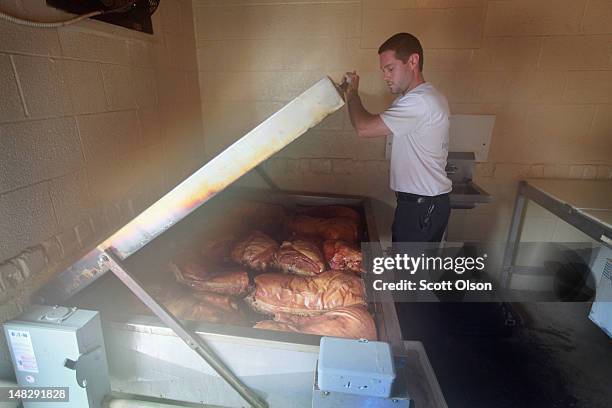 Steve Spoon checks on quartered pigs in his smoker at Bill Spoon's Barbecue on July 12, 2012 in Charlotte, North Carolina. The nearly fifty-year-old...