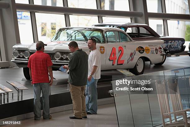 Visitors look at race cars at the NASCAR Hall of Fame on July 11, 2012 in Charlotte, North Carolina. In addition to cars, driver and team...
