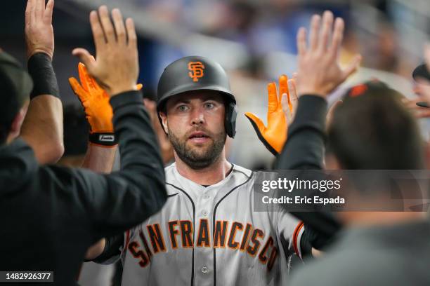 Darin Ruf of the San Francisco Giants is congratulated by teammates after scoring in the second inning against the Miami Marlins at loanDepot park on...