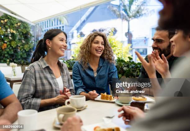 freunde, die sehr glücklich aussehen und sich in einem café unterhalten - kaffeeklatsch stock-fotos und bilder