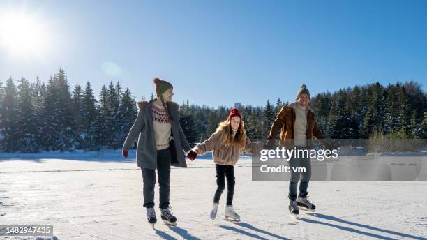 family ice skating on frozen  lake - family ice nature stock pictures, royalty-free photos & images