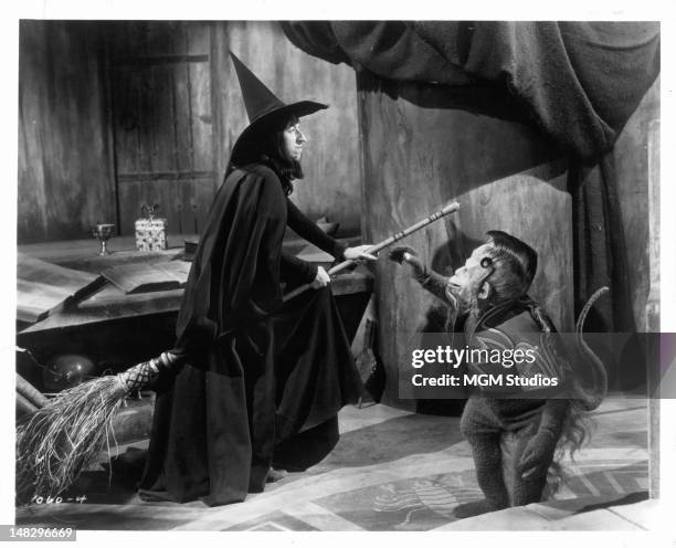 Margaret Hamilton as the Wicked Witch of the West gets ready to fly away as one of her flying monkey's reaches for her in a scene from the film 'The...