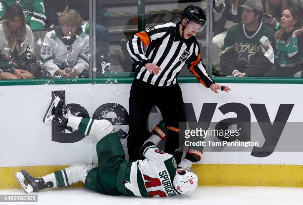 Jared Spurgeon of the Minnesota Wild collides with referee TJ Luxmore taking on the Dallas Stars in the first overtime period in Game One of the...