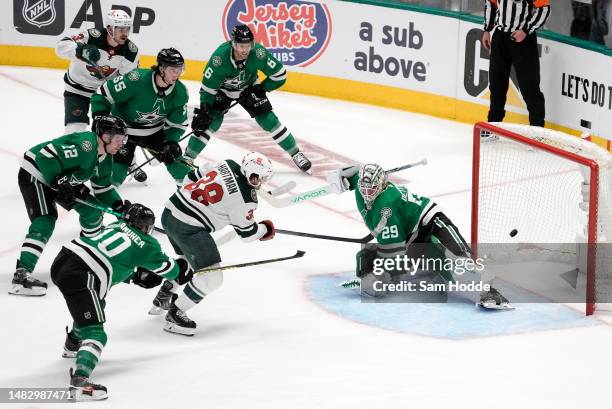 Ryan Hartman of the Minnesota Wild scores a goal past Jake Oettinger of the Dallas Stars in the second overtime period in Game One of the First Round...