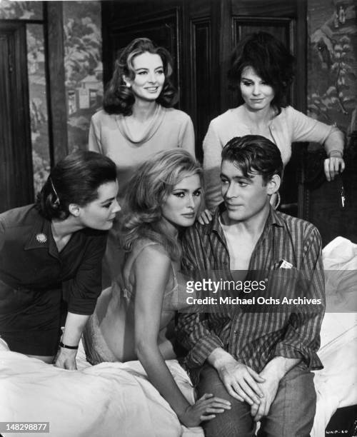 Romy Schneider, Capucine, Ursula Andress, Peter O'Toole, and Paula Prentiss gathered around bed in a scene from the film 'What's New Pussycat', 1965.