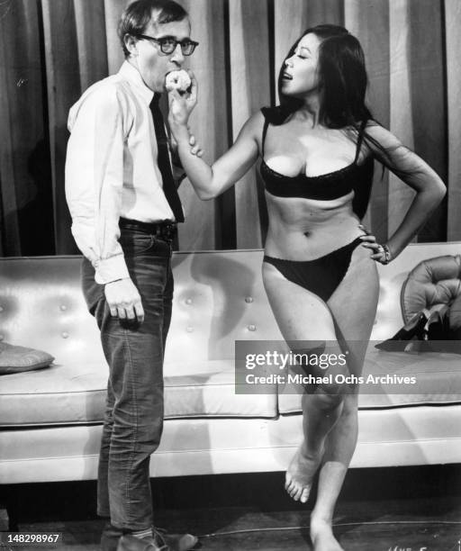 Woody Allen getting apple from Akiko Wakabayashi in a scene from the film 'What's Up, Tiger Lily?', 1966.