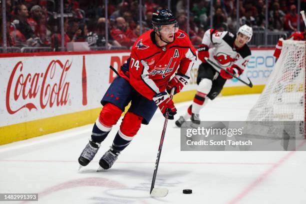 John Carlson of the Washington Capitals skates with the puck in front of Nico Hischier of the New Jersey Devils during the first period of the game...