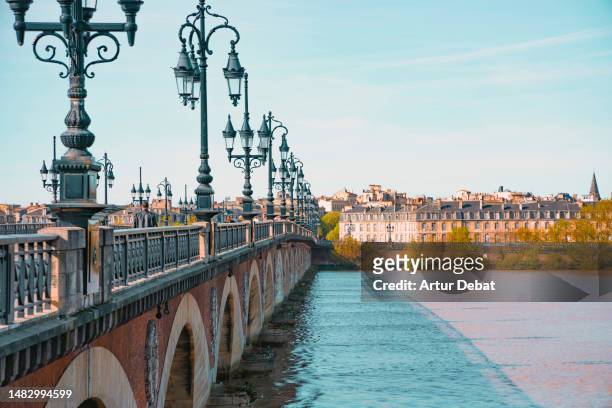 the city of bordeaux with le pont de pierre crossing the garonne river. - aquitania fotografías e imágenes de stock
