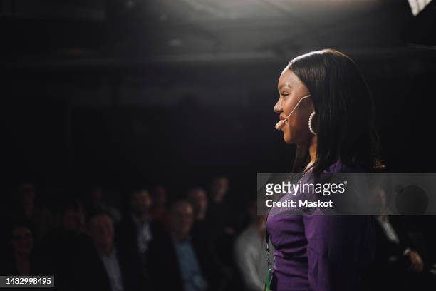 side view of smiling female tech entrepreneur speaking to audience at tech event - conference speaker stock pictures, royalty-free photos & images